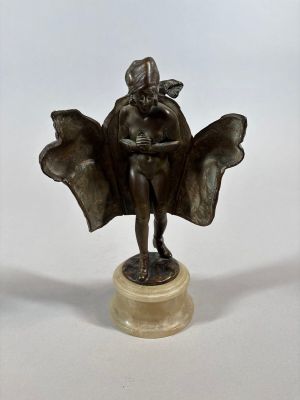 bronze statue of a woman sitting on a pedestal with her arms folded over her head