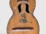 an old wooden guitar with a dragon design on the back of it