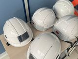 several white hard hats sitting on top of a table in a room