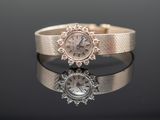 a close up of a watch on a reflective surface
