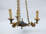 a chandelier with three candles hanging from it