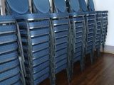 rows of blue chairs in a room with a wooden floor