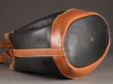 a black and brown leather bag with a tan strap