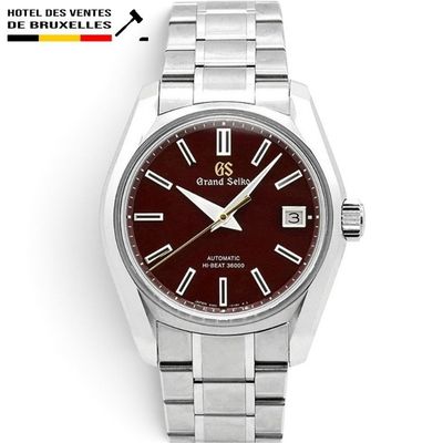 a close up of a wrist watch with a red dial