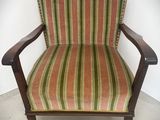 une vieille chaise dont l'assise est recouverte d'un tissu rayé