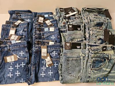Plusieurs paires de jeans pour homme sont empilées les unes sur les autres