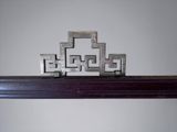 a metal sculpture of a cross on top of a shelf