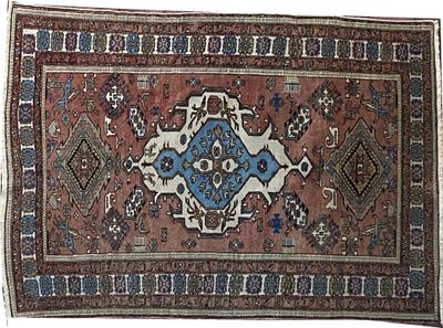 un vieux tapis orné d'un motif bleu et marron sur fond blanc