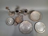 a lot of silver plates and cups on the table