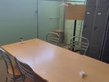 des tables et des chaises dans une pièce, avec des casiers en arrière-plan