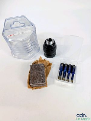 le contenu d'une bouteille d'eau, des piles et d'autres objets sont disposés sur une surface blanche