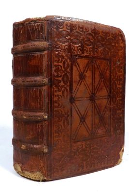 an old book with a wooden cover sitting on top of a white surface