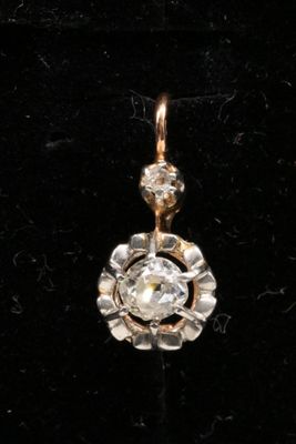a close up of a diamond pendant on a black velvet surface