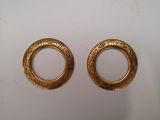two gold tone earrings with a circular design on them