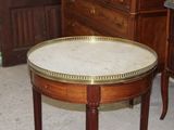 a small table with a marble top on a carpeted floor