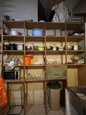 shelves with pots and pans on top of them in a kitchen