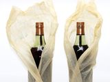 two bottles of wine wrapped in plastic bags on the table