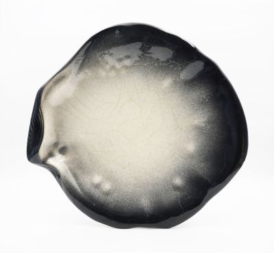 une assiette noire et blanche posée sur une surface blanche