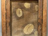 an old wooden frame with a painting of leaves on it