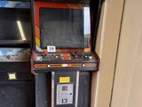 une petite borne d'arcade posée dans un coin d'une pièce