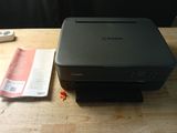 an image of a printer sitting on a table next to a book