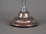 a silver statue of a woman holding a cross on a pedestal