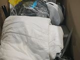 a cardboard box filled with a bed and a pile of luggage