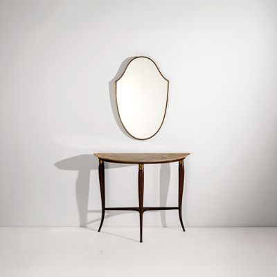 un miroir ovale posé sur une petite table, avec une autre petite table en dessous