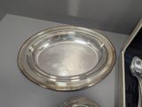a silver plate with a spoon and a spoon rest on a table