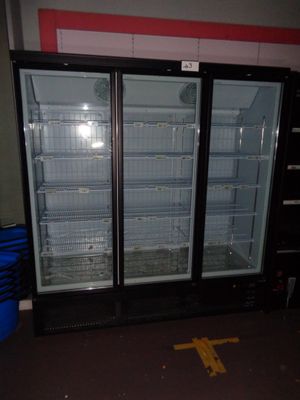 two refrigerators that are open in a room