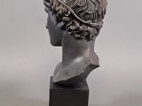 statue of a woman ' s head with curly hair on a marble base