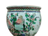 an image of a vase with a woman sitting on a bench in a garden