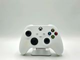 a close up of a white controller on a white surface