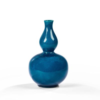 un vase bleu posé sur une surface blanche