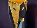 a black and gold sculpture of a man with a tie