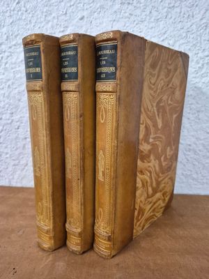 three old books sitting on top of a table next to each other