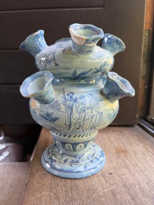 a blue and white vase sitting on a wooden table