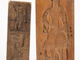 deux sculptures sur bois représentant un homme et un chien sur fond blanc