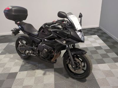 a black motorcycle parked in a room with a checkered floor