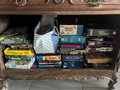 de nombreux jeux de société empilés sur une table en bois