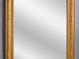 a gold framed mirror against a gray wall