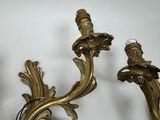 two gold candles that are on the wall