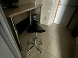 une chaise noire placée devant un bureau dans une pièce
