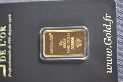 a close up of a gold bar on a card on a table