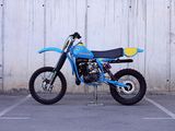 a blue dirt bike parked in a parking lot