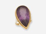 une bague en or ornée d'une pierre d'améthorate au centre