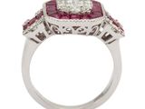 a close up of a diamond and ruby ring on a white background