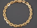 a gold bracelet with leaves on a black background