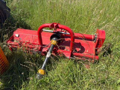 une petite machine rouge qui est posée dans l'herbe