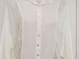 white shirt on a mannequin display in a white room
